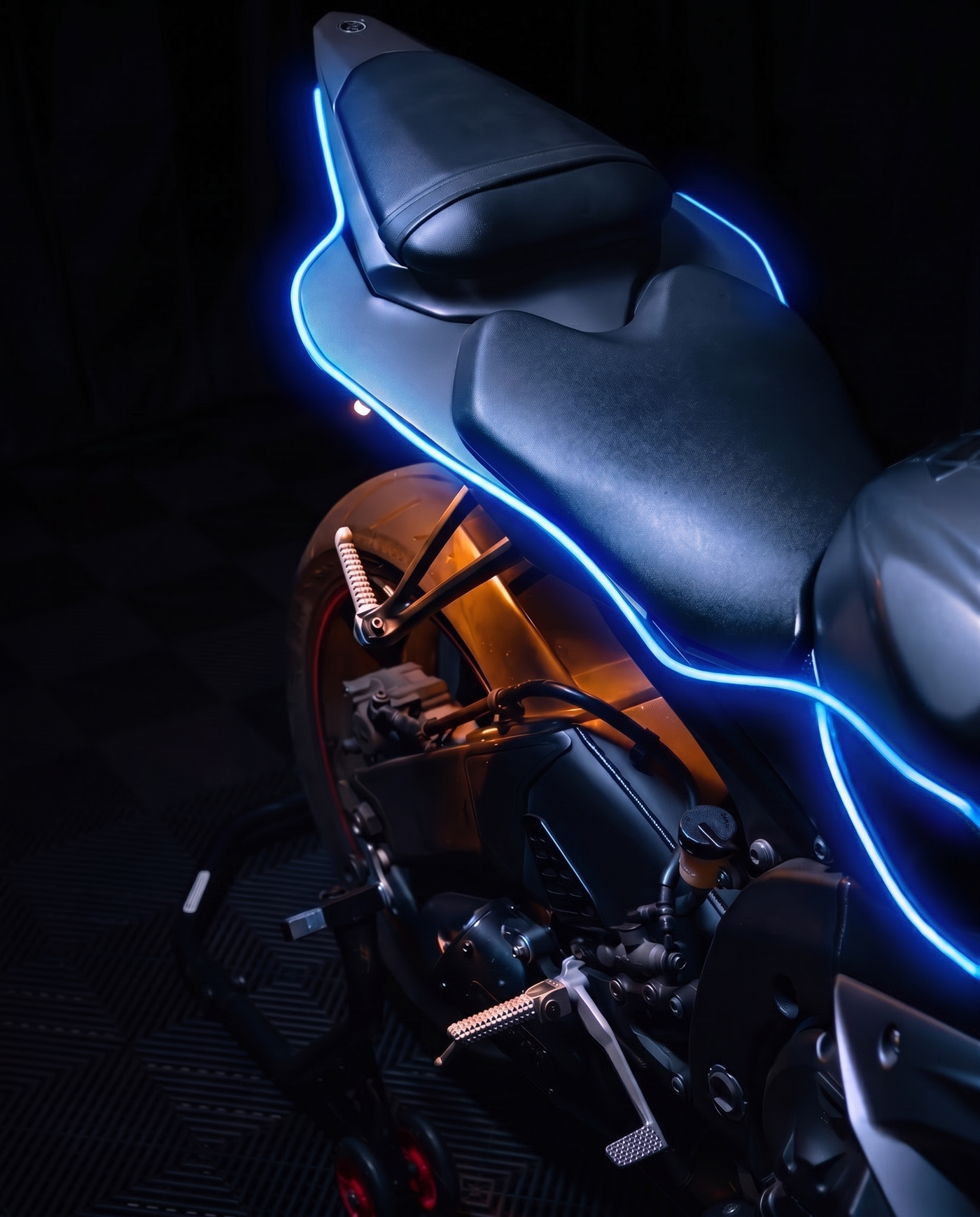 Close-up of a sport bike's seat and tail, a single blue NYTRON strip tracing the edge of the bodywork.