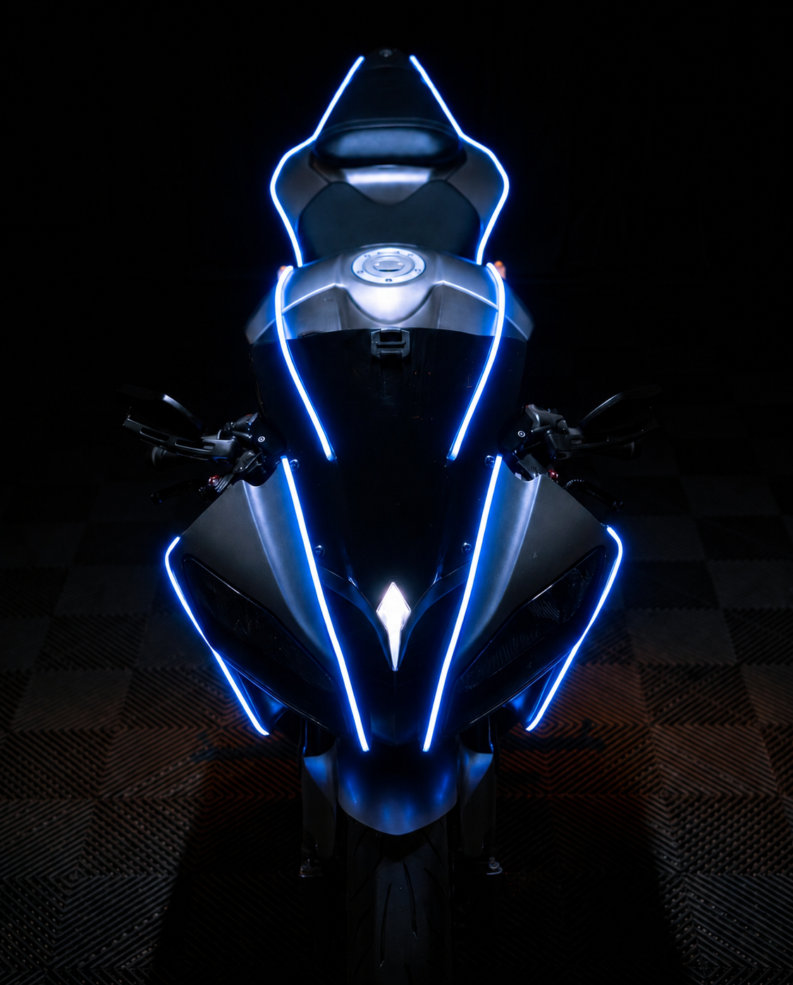 Head-on view of a sport bike, blue NYTRON contour lighting tracing the fairing, windscreen, tank and seat.