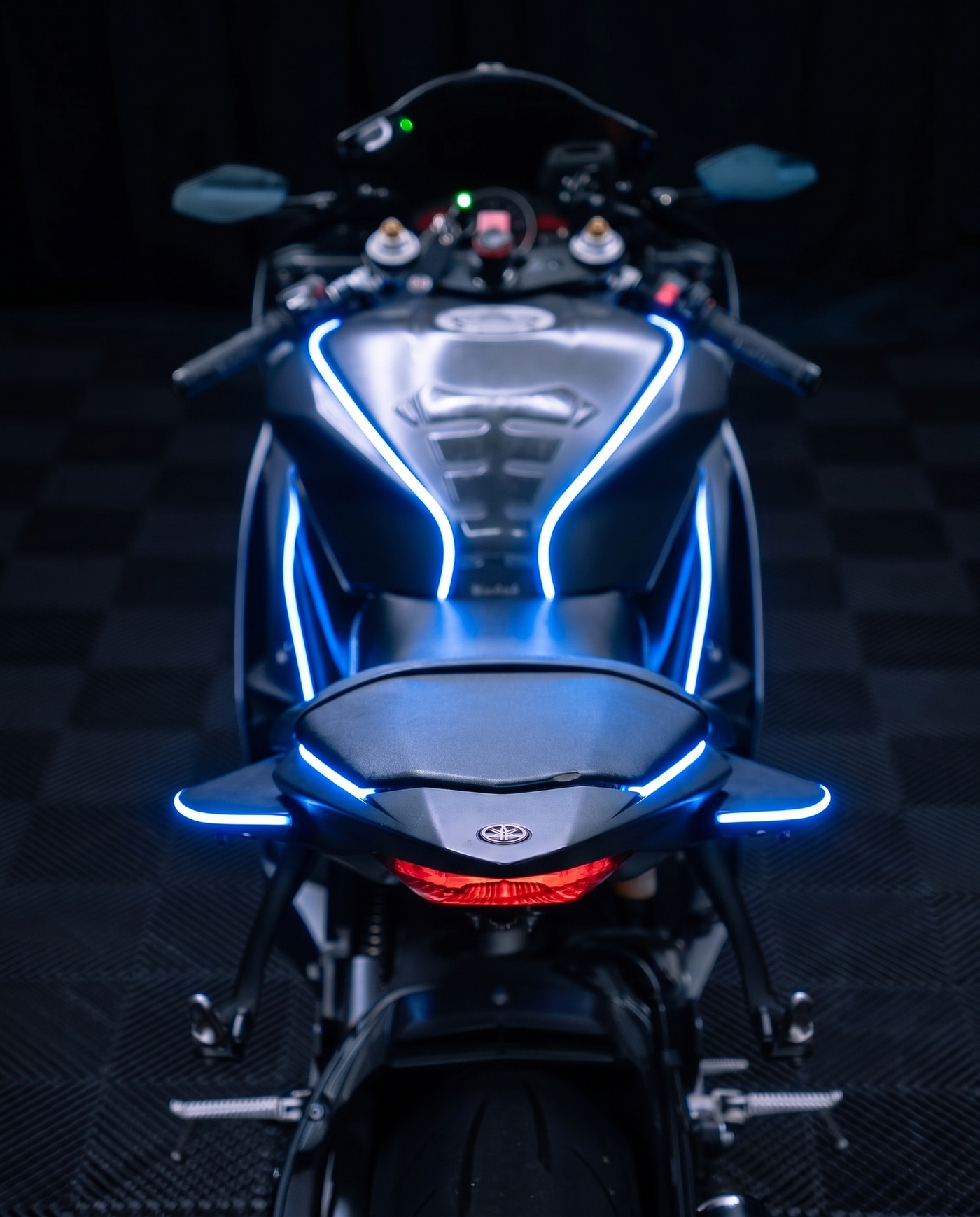 Rear view along a sport bike, blue NYTRON contour lighting tracing the tank and tail, red taillight lit.